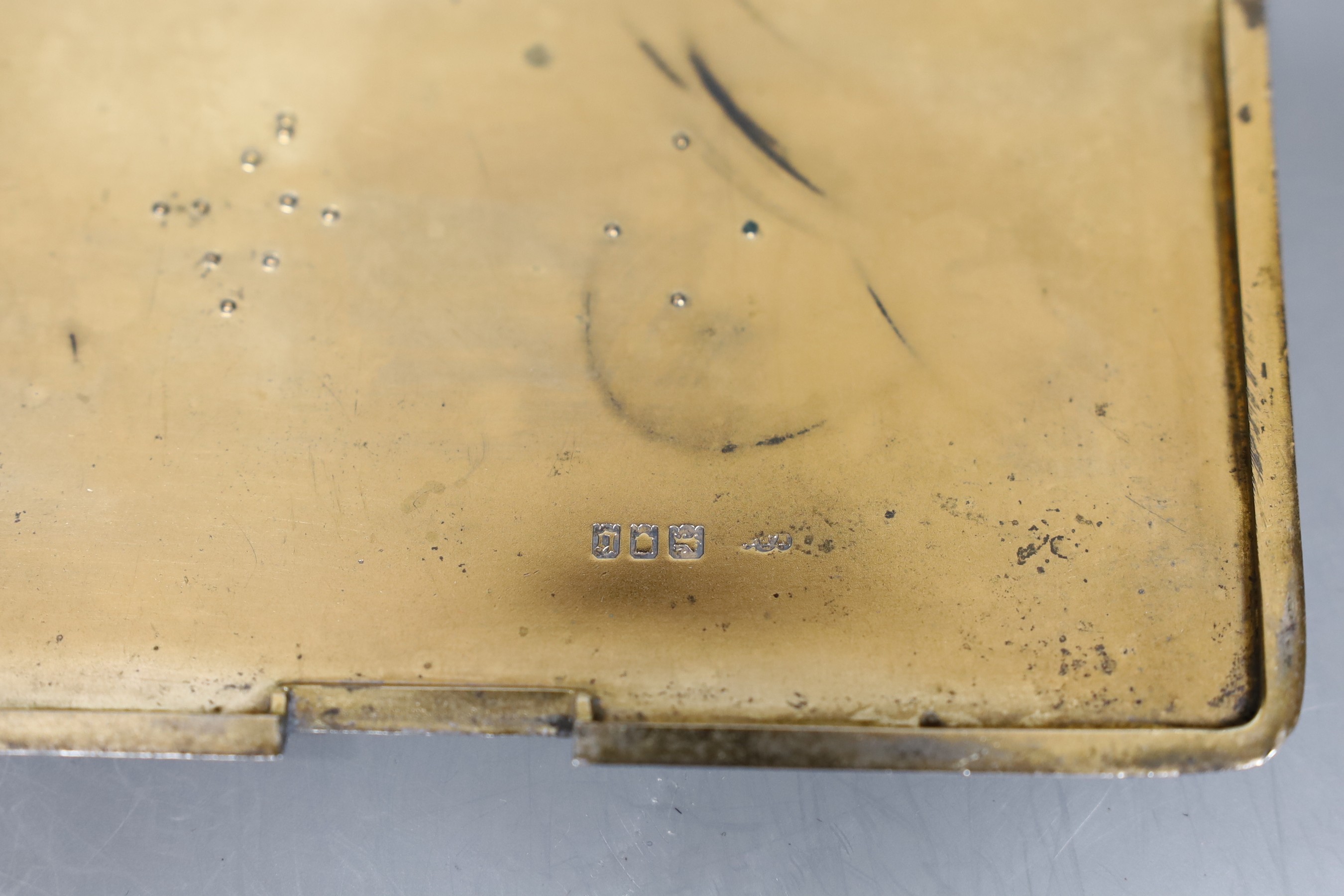A Finnigans silver engine turned cigarette case with gilt interior mounted with gold Manchester Regiment 'Egypt' badge and family crest, London 1917, width 13cm